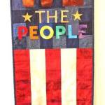 Flag colors appear in a pieced and appliquéd fiber art We the People wall hanging by Elizabeth Bolton. I need to focus on the strength and resilience of our population as we navigate these turbulent times, she noted.