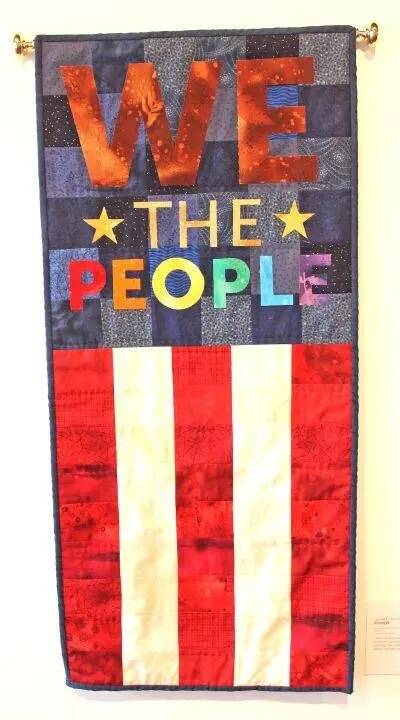 Flag colors appear in a pieced and appliquéd fiber art We the People wall hanging by Elizabeth Bolton. I need to focus on the strength and resilience of our population as we navigate these turbulent times, she noted.